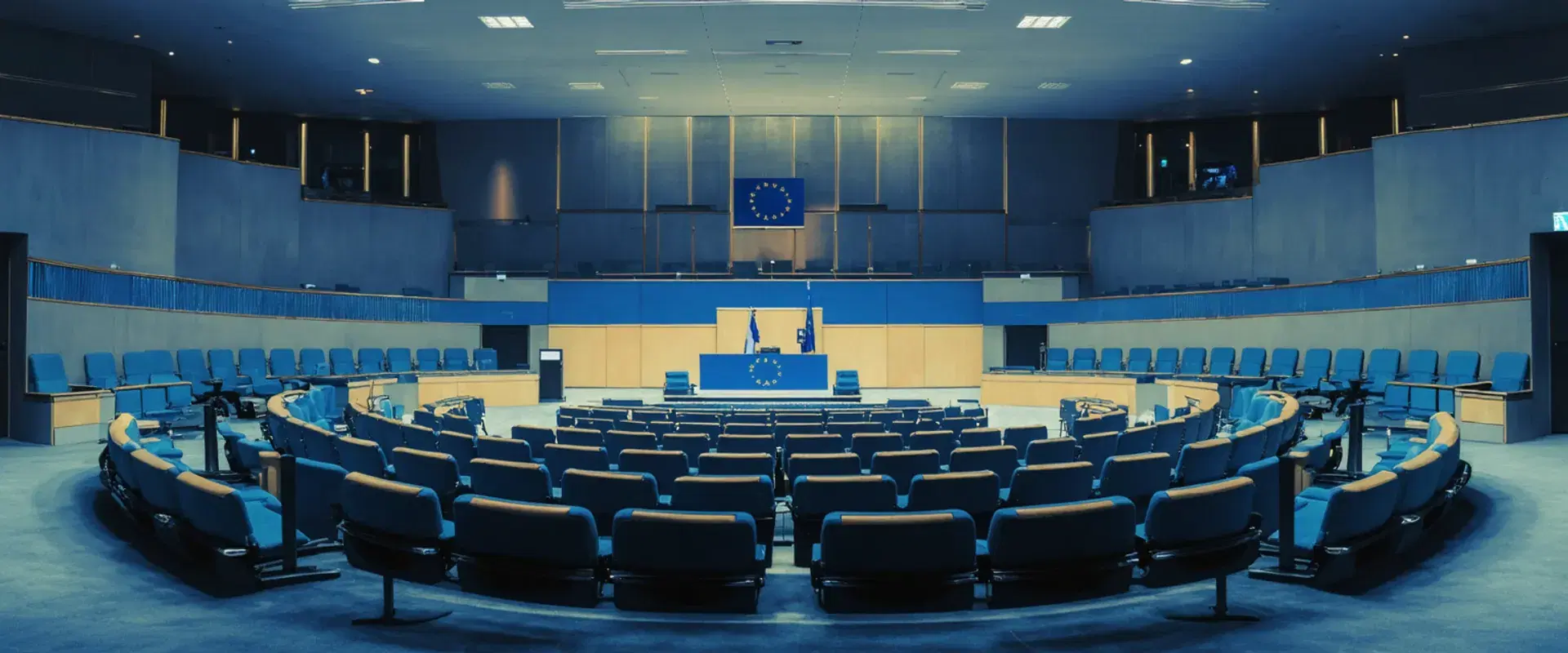 Soft-focus interior of a formal European regulatory chamber at dusk with an EU flag in the background.